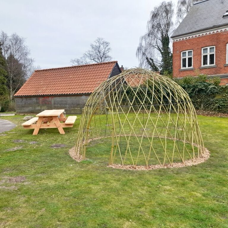 Nyflettet pilehytte og et bord-bænke-sæt