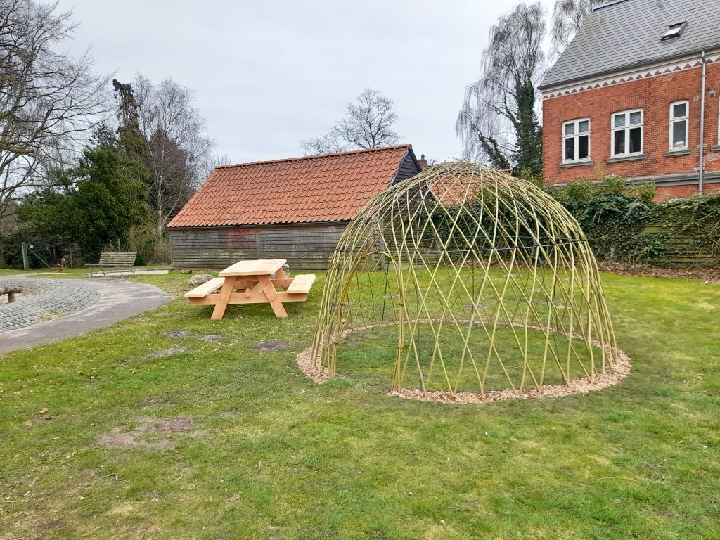Nyflettet pilehytte og et bord-bænke-sæt