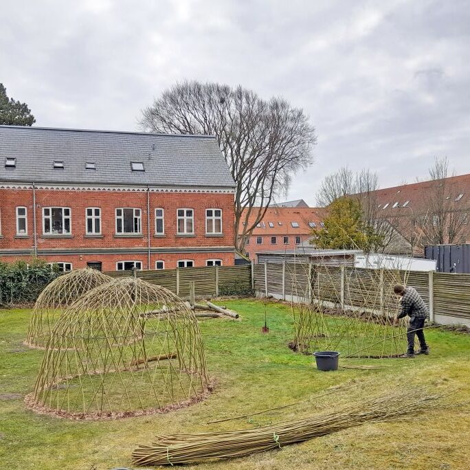 Legeplads hvor 3 levende pilehytter er ved at blive flettet